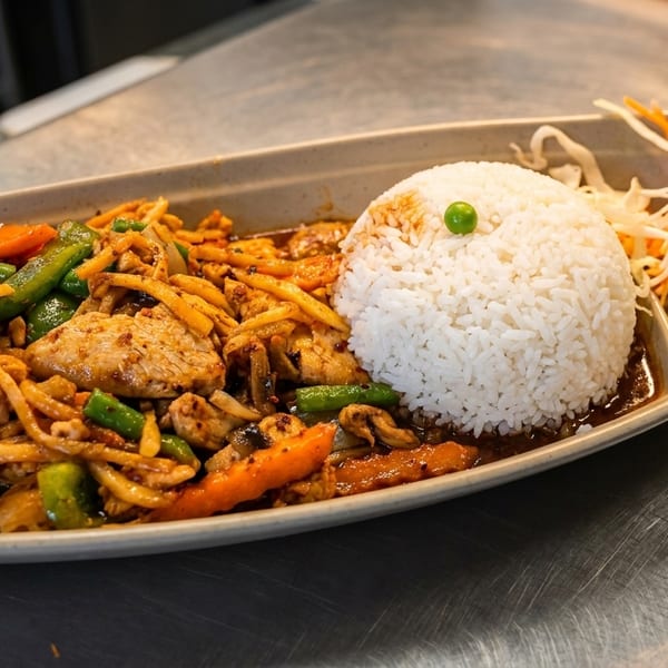 Spicy chicken stir-fry with bamboo shoots, green beans, carrots, rice, and a side salad.